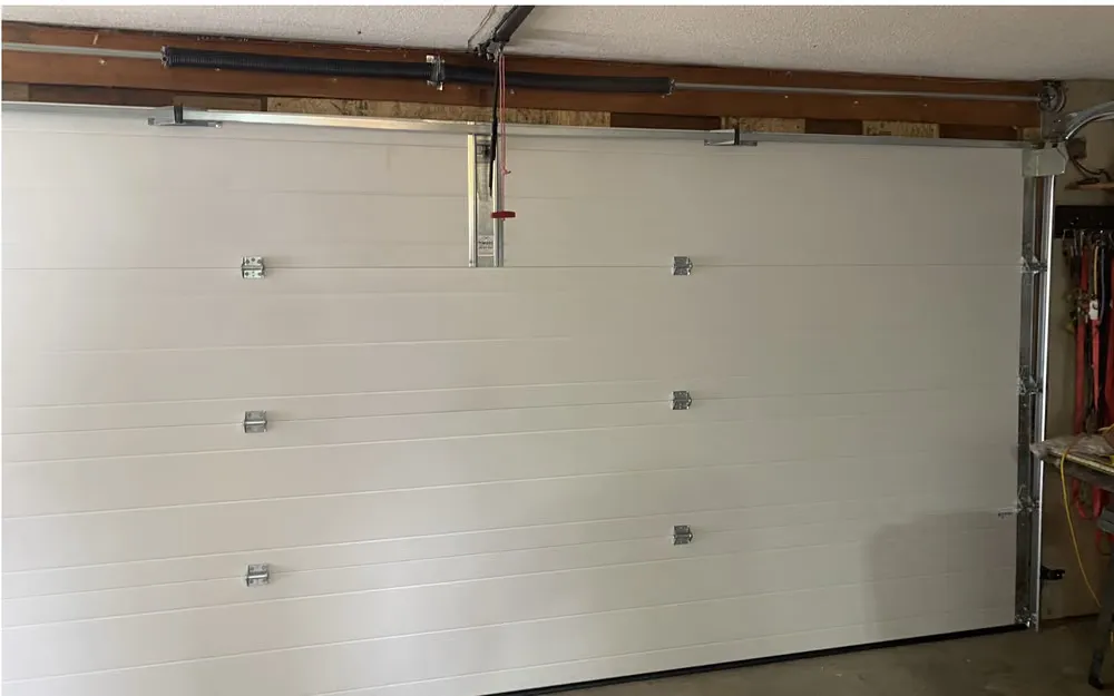 Inside the same garage, a smooth white steel door sitting tight to the floor