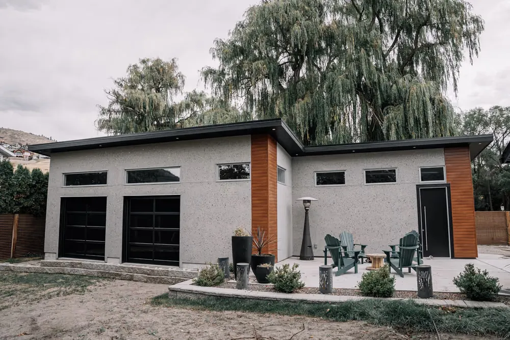 A pair of black sectional garage doors on a modern home with cedar accents