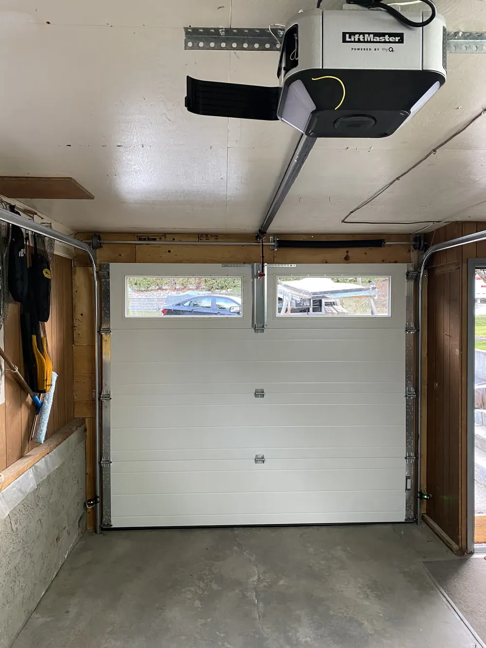 A white garage door and a newly installed LiftMaster opener seen from inside the garage